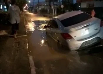Carro de passeio cai em cratera após alfalto ceder com vazamento de água no Bairro Grageru